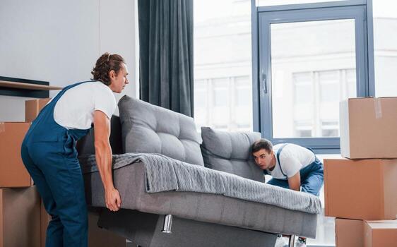 Two movers carrying a sofa